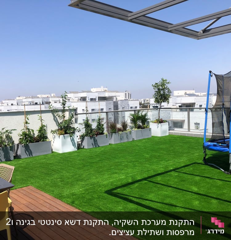 עציצים עם צמחים על דשא מלאכותי במרפסת